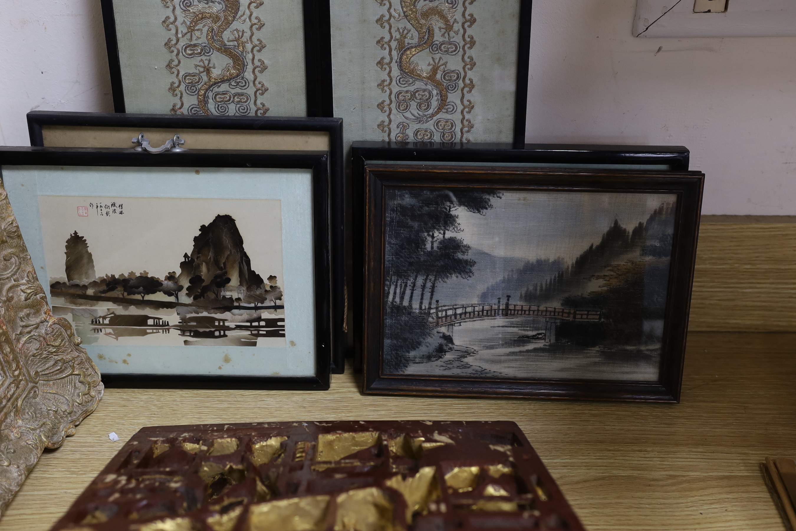 A Chinese carved giltwood ‘warriors’ panel, 45cm x 30cm a pair of sleeve bands and three framed Chinese cut feather pictures and a Japanese painted velvet picture